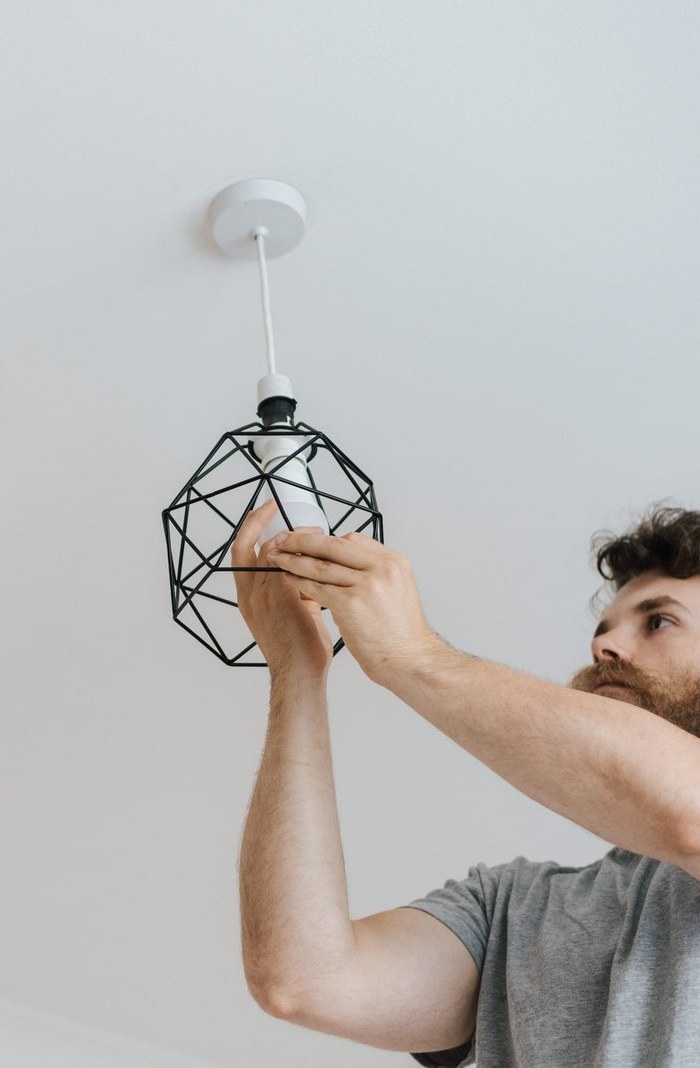 Elektriker installerar en taklampa i ett hem
